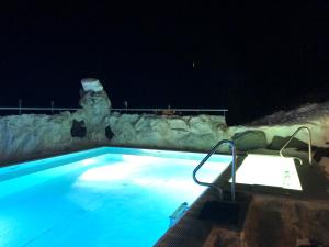 uma piscina à noite com as luzes acesas em panoramasuite Turracherhöhe em Turracher Hohe