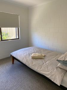 Un dormitorio con una cama con una toalla. en Coastal Soul STA - MTA, en Tin Can Bay