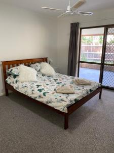 a bed in a bedroom with a ceiling fan at Coastal Soul STA - MTA in Tin Can Bay