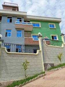 ein grün-weißes Gebäude mit einem Balkon in der Unterkunft Studio meublé haut standing jouvence Yaoundé in Jaunde