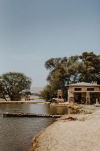 a building sitting on the shore of a river at African Leaves Trout Lodge in Dullstroom