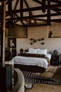 a bedroom with a large bed with a zebra print rug at African Leaves Trout Lodge in Dullstroom