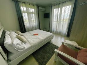 niewielka sypialnia z łóżkiem i oknem w obiekcie Tenexia - Morne Brabant Studio w mieście La Gaulette