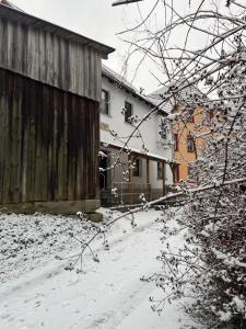 a snow covered yard with a fence and a house at Ferienwohnung Schlossberg 2 in Wirsberg