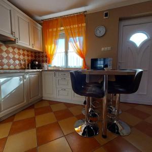 a kitchen with a table and two bar stools at Mediterrán Vendégház in Nagyatád