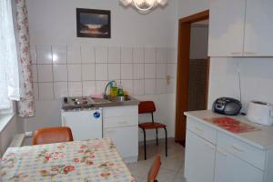 eine Küche mit einem Tisch und einem Waschbecken sowie einem Tisch und Stühlen in der Unterkunft Wohnung in Mellenthin - a55965 in Mellenthin