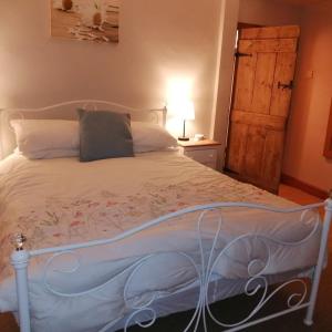 a bedroom with a white bed with a wooden door at Church cottage in Lincolnshire