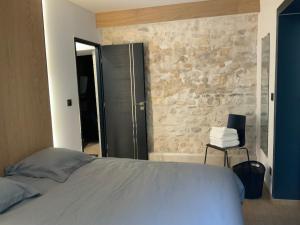ein Schlafzimmer mit einem Bett und einer Steinmauer in der Unterkunft Le charme de l'ancien in Bourges