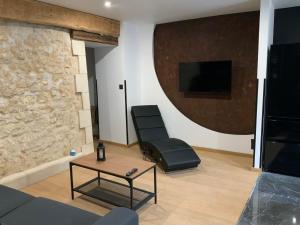 - un salon avec un canapé et une chaise dans l'établissement Le charme de l'ancien, à Bourges