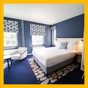 una camera con letto king-size e sedia di The Fallon Hotel Alkmaar ad Alkmaar