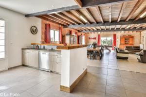 una cucina e un soggiorno con tavolo e sedie di DOMAINE DE LA PORTE ad Agonac