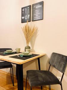 a dining room table with two chairs and a chalkboard at Saniertes Studio - Elisa - mit Balkon, WLAN, Smart-TV & Küche in City-Nähe in Erfurt
