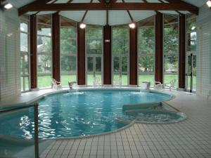 a large swimming pool with chairs in a building at T2 + Tout Confort + Terrasse in Aulus-les-Bains