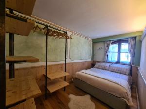a small bedroom with a bed and a window at Bilocale Ristrutturato in Madesimo