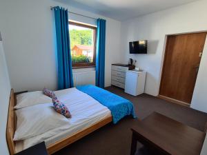 a bedroom with a bed with blue curtains and a window at Hawira in Mielno