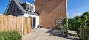 a house with a wooden fence and a patio at Vakantiewoning Zwinstraat Zoutelande in Zoutelande