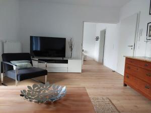 ein Wohnzimmer mit einem TV und einem Stuhl in der Unterkunft Landpartie in Freckenfeld