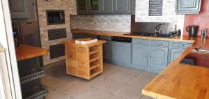 a kitchen with blue cabinets and a counter top at Appartement 4 chambres Sur la Cave in Givet