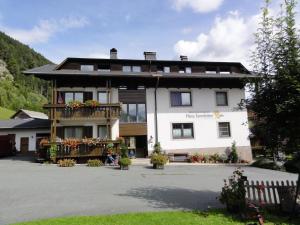 a large white building with a balcony at Ferienwohnungen im Haus Sonnleiten am Weissensee in Techendorf
