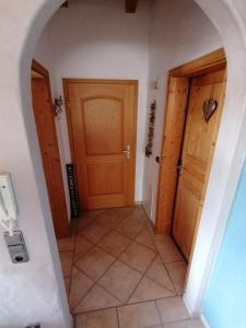 a hallway with two wooden doors and a tile floor at Ferienwohnung in Lechbruck am See im schönen Allgäu, nahe Füssen nur 300 m vom See in Lechbruck