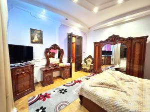 a bedroom with a bed and a tv and mirrors at Hotel Royal in Kutaisi
