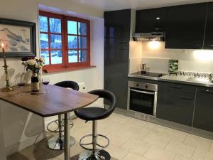 a kitchen with a wooden table and two bar stools at Pastourelle in Quarré-les-Tombes +16 photos