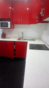 a kitchen with red cabinets and a sink at Buttercream in Durban