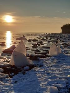 a group of ice formations on a beach with the sun setting at Ferienwohnung Gerda in Groß Stresow