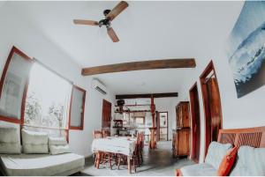 a living room with a table and a ceiling fan at Guarda do Embaú Aluguél Casa 300mts Praia in Guarda do Embaú
