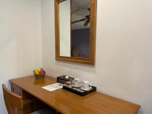 un tavolo in legno con specchio e un vassoio con bicchieri di The Pavillon by The Pace Phuket Boutique Resort a Rawai Beach