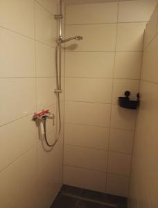 y baño de azulejos blancos con ducha. en Ferienwohnungen Ilona Blick en Kelberg