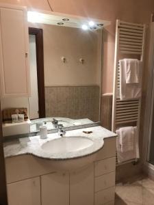 a bathroom with a sink and a large mirror at NANDO in Bellagio