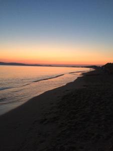 una puesta de sol en una playa con el océano en Mare Monte Studios Naxos, en Plaka