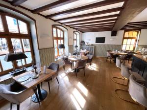 a restaurant with tables and chairs in a room with windows at Das Hotel Krone in Königswinter