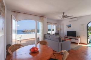 a living room with a table and a couch at Belvedere, Family-friendly, Nice, First-line Apartment with Stunning Beach and Sea views,AC in Arenal d'en Castell