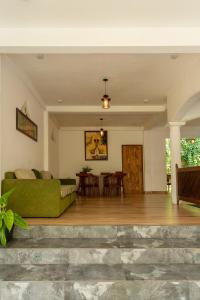 a living room with a green couch and a table at Deltora Villa - free drop off to Galle Fort by TukTuk in Galle