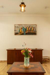 un jarrón de flores sobre una mesa en una habitación en Deltora Villa - free drop off to Galle Fort by TukTuk en Galle