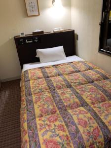 金沢市にある金沢フレックスホテルのカラフルなキルトのベッド1台
