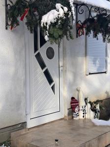 a white door with a christmas wreath on it at Hotel Окремий Будинок-Апартаменти in Rakoshyno