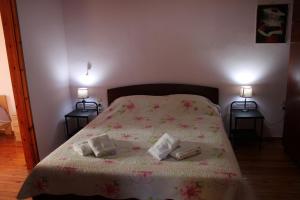 a bedroom with a bed with two pillows on it at Komninos' Traditional House in Artemida