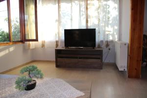 Una sala de estar con un televisor de pantalla plana sobre un soporte. en Komninos' Traditional House, en Artemida