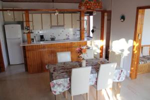Una cocina con una mesa y sillas y un fregadero. en Komninos' Traditional House, en Artemida