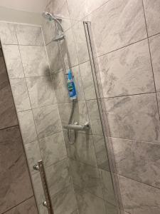 a shower with a glass door in a bathroom at Cinderhouse Highbury Vale in Nottingham