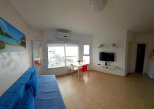 sala de estar con sofá azul y mesa en Hotel Apartment TLV-bat yam 81, en Bat Yam