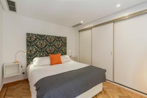- une chambre avec un lit et un oreiller orange dans l'établissement Homelike Sol - Gran Via I, à Madrid