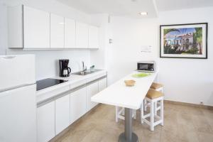 a kitchen with white cabinets and a white counter top at San Nicolás in Playa del Ingles