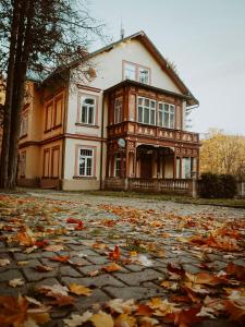 uma casa com folhas no chão à sua frente em Villa Belvedere em Janske Lazne