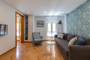 a living room with a couch and a chair at Homelike Sol - Gran Via I in Madrid