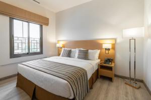 a bedroom with a large bed and a window at Aram Hotel - AlMeshael Exit 18 in Riyadh