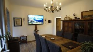 a dining room with a table and a television on the wall at Heckes Ferienwohnung in Schöneiche